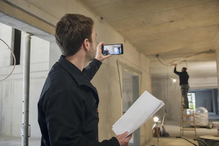 Bauleiter kontrolliert auf einer Baustelle einen Tagesbericht und den Baufortschritt