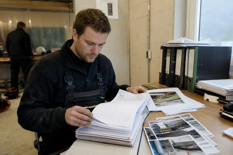 Bauakten mit Tagesberichten, Fotos und Mängelprotokollen auf einem Schreibtisch